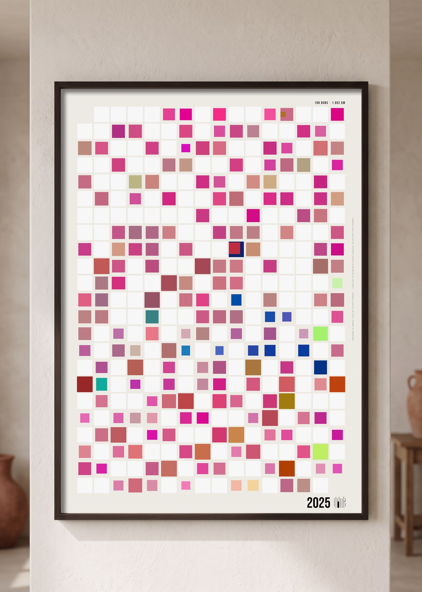 A year of runs printed as a grid of coloured tiles, framed on a wall